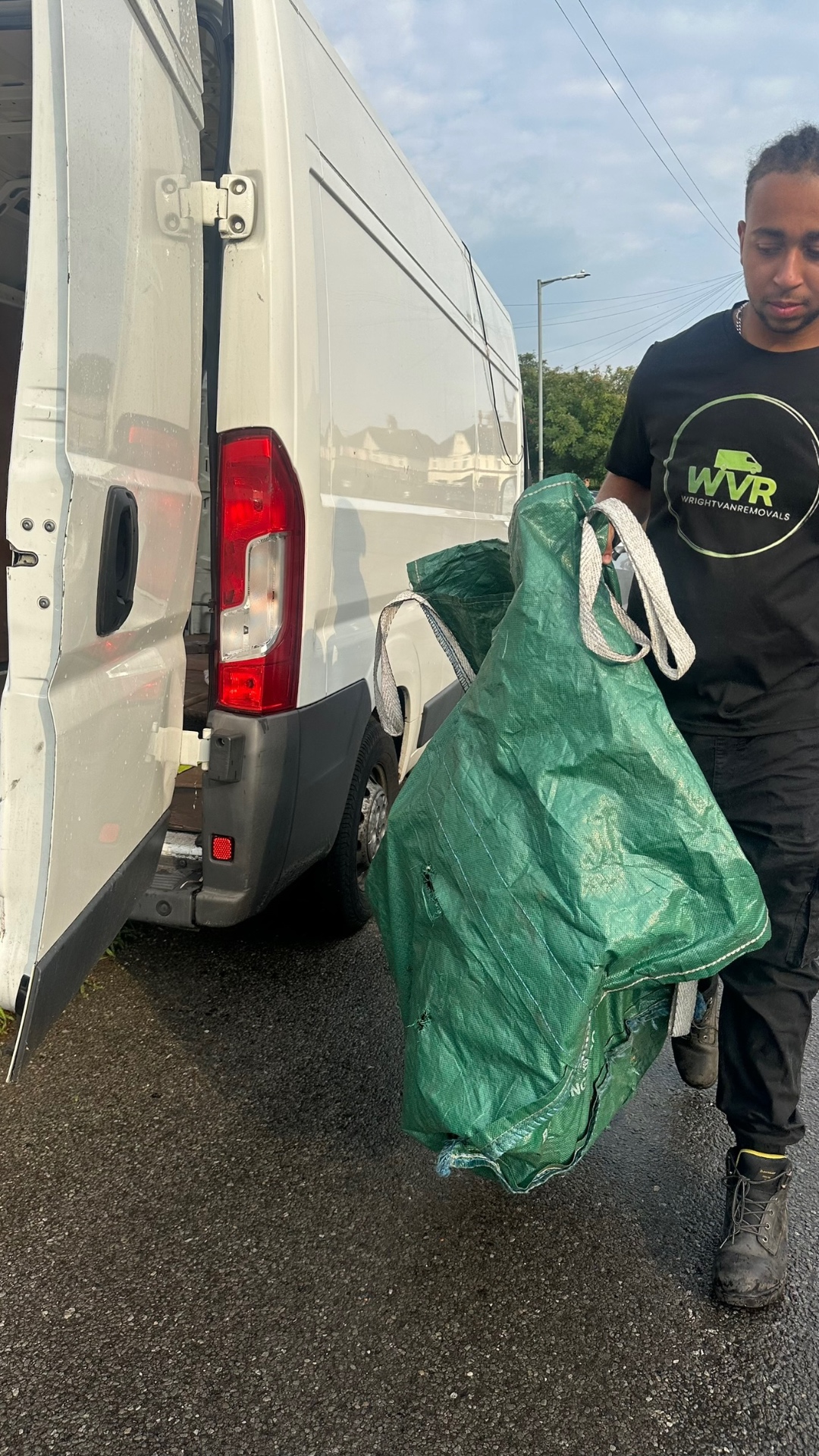 WVR crew carrying a heavy-duty waste bag to the van - garden & bulky waste removal